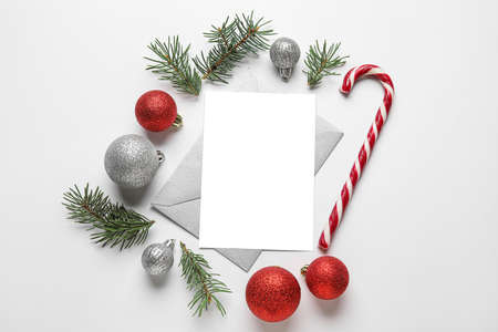 Blank card, fir tree branches, Christmas balls and candy stick on white background