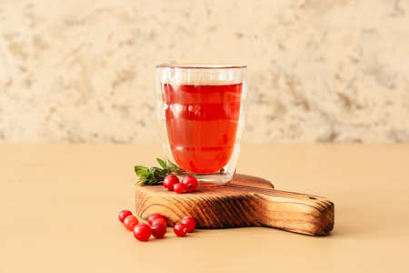 Glass of tasty lingonberry tea on tableの写真素材