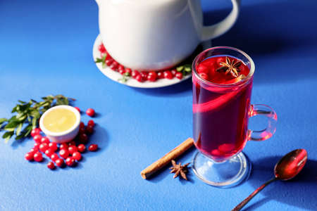 Glass of tasty lingonberry tea on color backgroundの写真素材