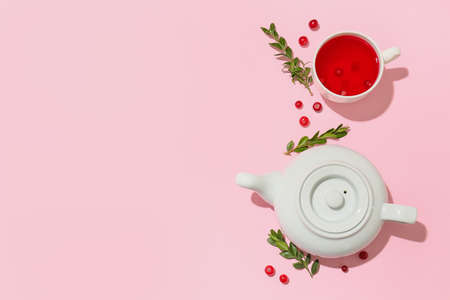 Composition with cup of tasty lingonberry tea and teapot on pink backgroundの写真素材