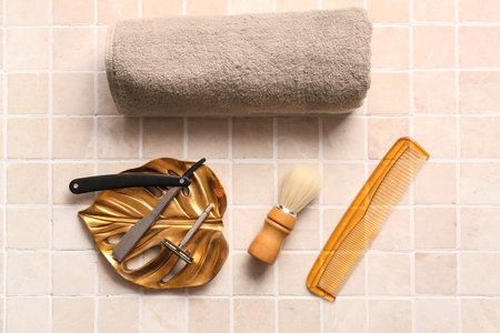 Stylish male accessories for shaving, towel and comb on tile backgroundの写真素材