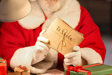 Santa Claus with letters at home on Christmas eve