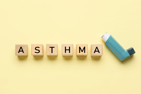 Wooden cubes with word ASTHMA and inhaler on yellow backgroundの写真素材
