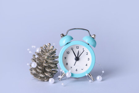 Christmas composition with alarm clock on color background