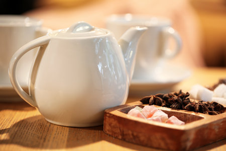 Tea pot, Turkish delight and star anise on table in cafeの写真素材