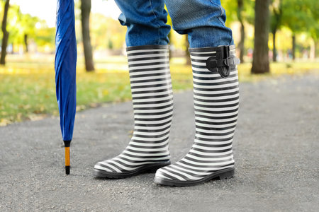 Young woman in gumboots outdoors on autumn dayの写真素材
