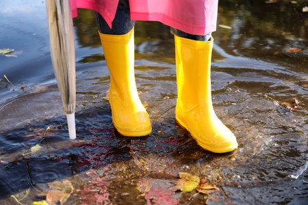 Young woman in gumboots outdoors on autumn dayの写真素材