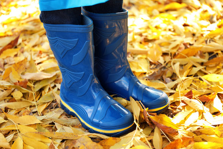 Child in gumboots outdoors on autumn dayの写真素材