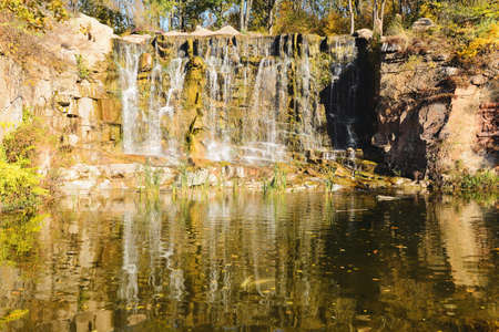 Beautiful view of lake and waterfall in autumn park