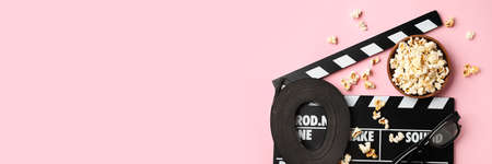 Bowl of popcorn, film reel, 3D glasses and clapperboard on pink background with space for text