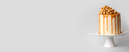 Tasty cake with popcorn and caramel on gray background with space for textの写真素材