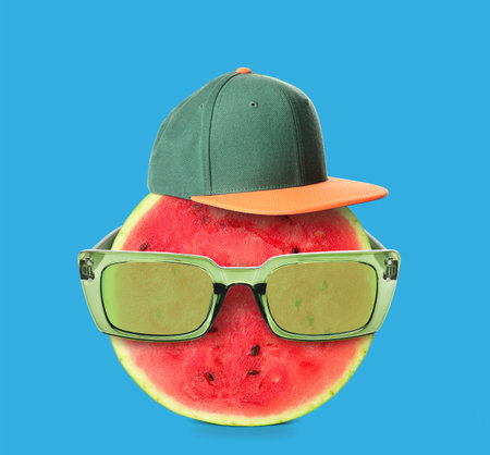 Funny watermelon wearing sunglasses and hat on blue backgroundの写真素材