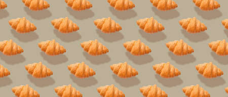 Many fresh croissants on gray background. pattern for designの写真素材