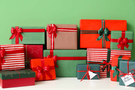 Chest of drawers with different Christmas presents on color background