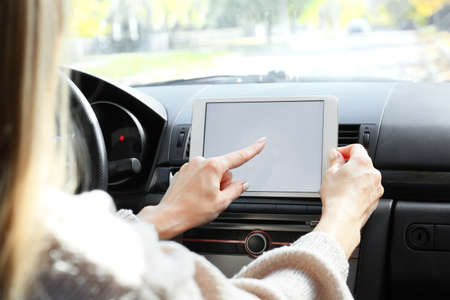 Female driver using tablet computer for navigation