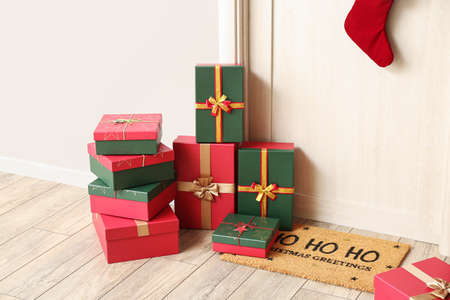 Christmas gift boxes near light wooden door