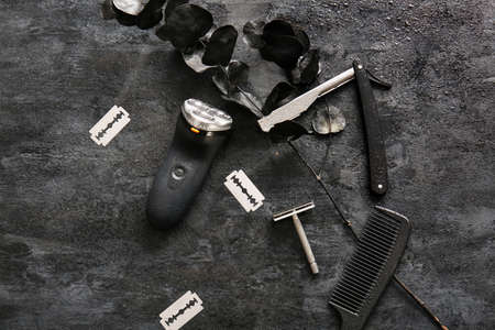 Modern electric shaver, hair combo and different shaving razors on black background