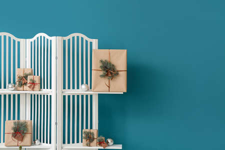 Folding screen with Christmas gifts and balls near blue wallの写真素材