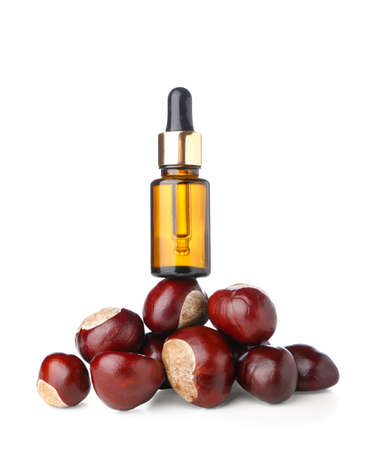 Bottle of essential oil and chestnuts on white backgroundの写真素材