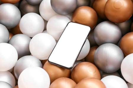 Mobile phone with blank screen on colorful plastic ballsの写真素材