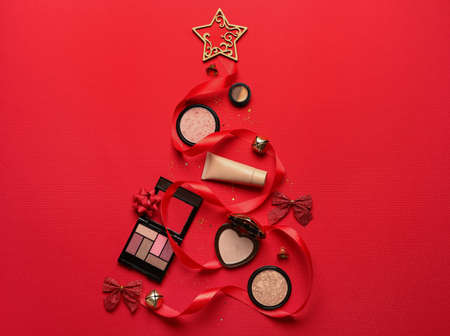 Christmas tree made of makeup cosmetics and decor on red backgroundの写真素材