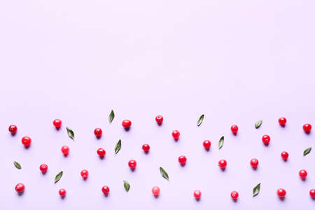 Ripe lingonberries with leaves on lilac background