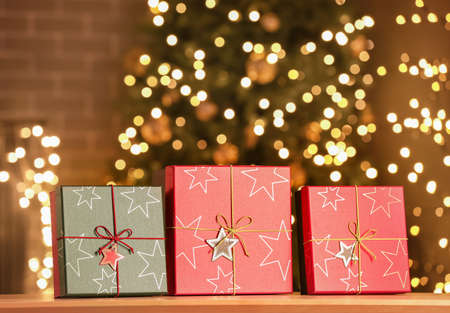 Christmas gift boxes on wooden table in room at nightの写真素材