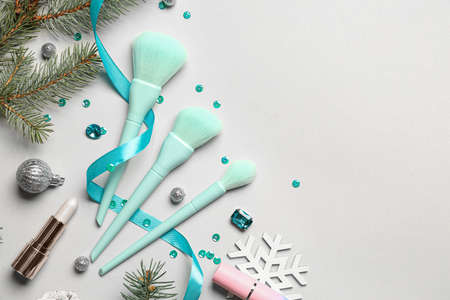 Makeup cosmetics with Christmas decor and fir branches on light backgroundの写真素材