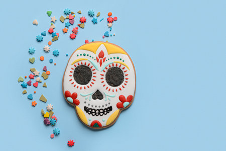 Skull shaped cookie with topping on blue background. El Dia de Muertosの写真素材