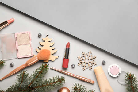 Makeup cosmetics with Christmas decor and fir branches on light backgroundの写真素材