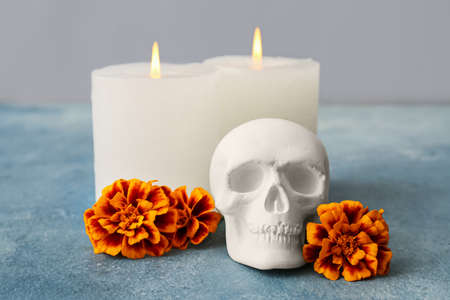 Human skull for Mexico's Day of the Dead (El Dia de Muertos) with candles and flowers on light backgroundの写真素材