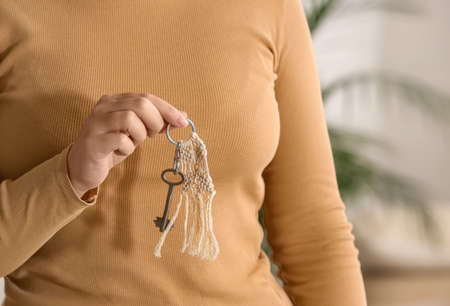 Woman holding key on chain, closeupの写真素材