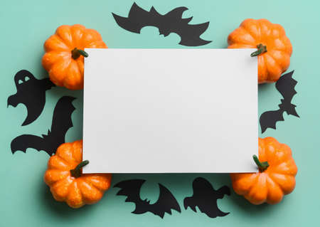 Blank paper sheet with pumpkins and Halloween decor on blue background