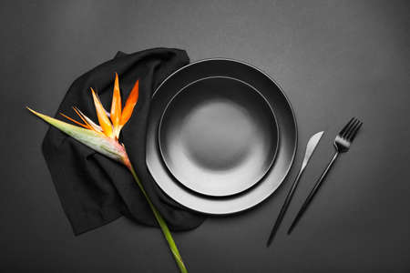 Simple table setting with bird of paradise flower on dark backgroundの写真素材