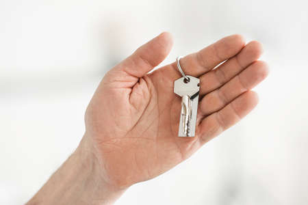 Male hand holding key on chain