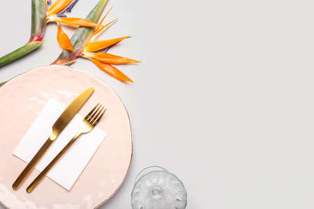 Simple table setting with bird of paradise flowers and blank card on gray backgroundの写真素材