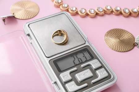 Jewelry scales with ring on pink backgroundの写真素材