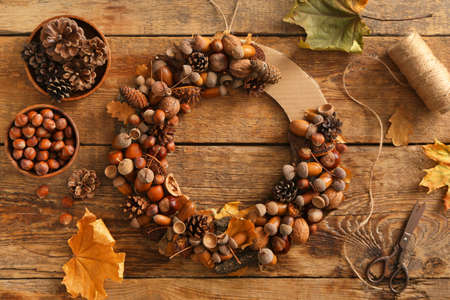 Composition with beautiful wreath made of pine cones and acorns on wooden backgroundの写真素材
