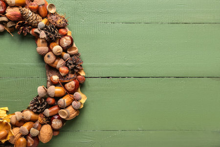 Beautiful acorn wreath on green wooden background