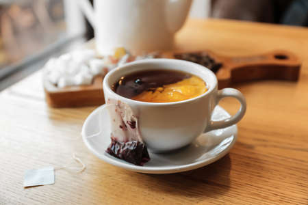 Cup with tea bag and lemon on table in cafe, closeupの写真素材