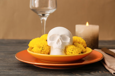 Plates with human skull and flowers on dark wooden table. Mexico's Day of the Dead (El Dia de Muertos)の写真素材