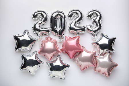Figure 2023 and different star shaped balloons on light background