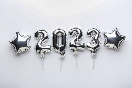 Figure 2023 and star shaped balloons on light background