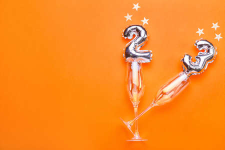 Figure 20 made of silver balloons and champagne glasses on color backgroundの写真素材