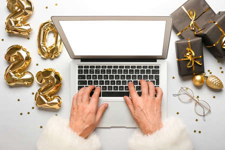 Santa Claus using laptop on white background