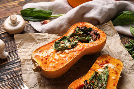 Parchment with tasty stuffed pumpkins on wooden backgroundの写真素材