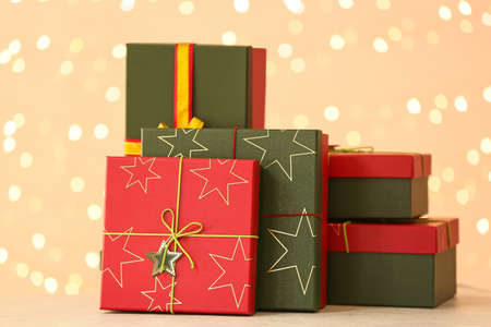 Christmas gift boxes on table against blurred lights