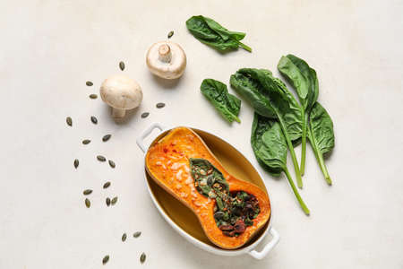 Baking dish with tasty stuffed pumpkin on light background