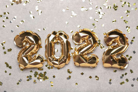 Balloons in shape of figure 2022 and confetti on light backgroundの写真素材