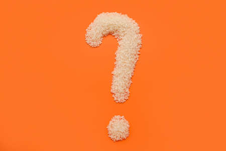 Question mark made of raw rice on red backgroundの写真素材